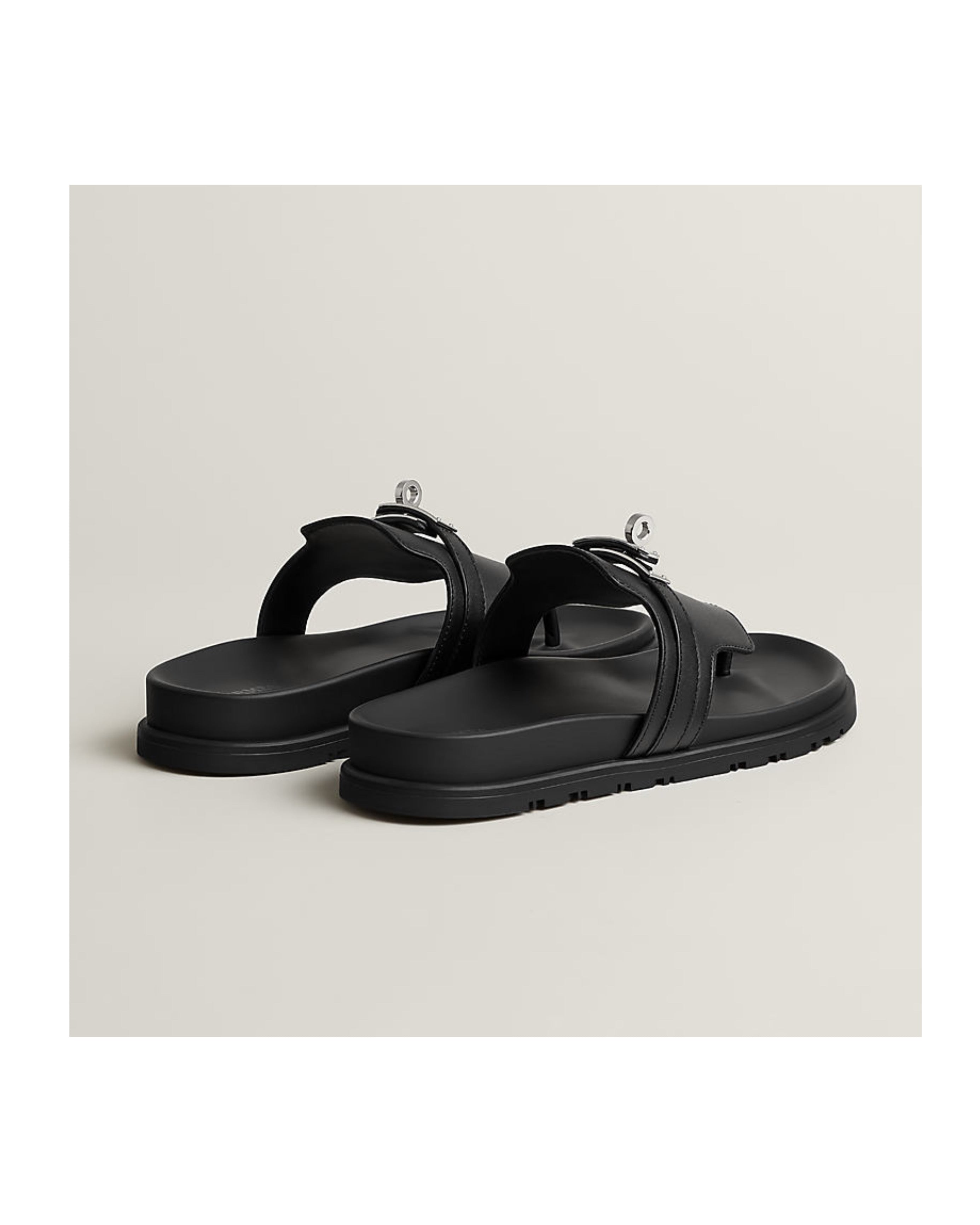 Black sandals on a light beige background
