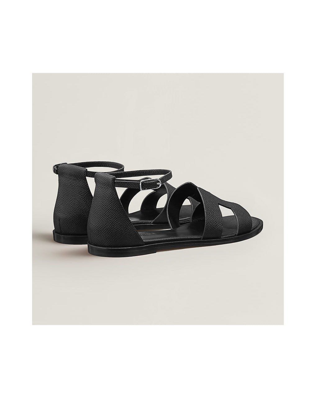 Black sandals on a light beige background