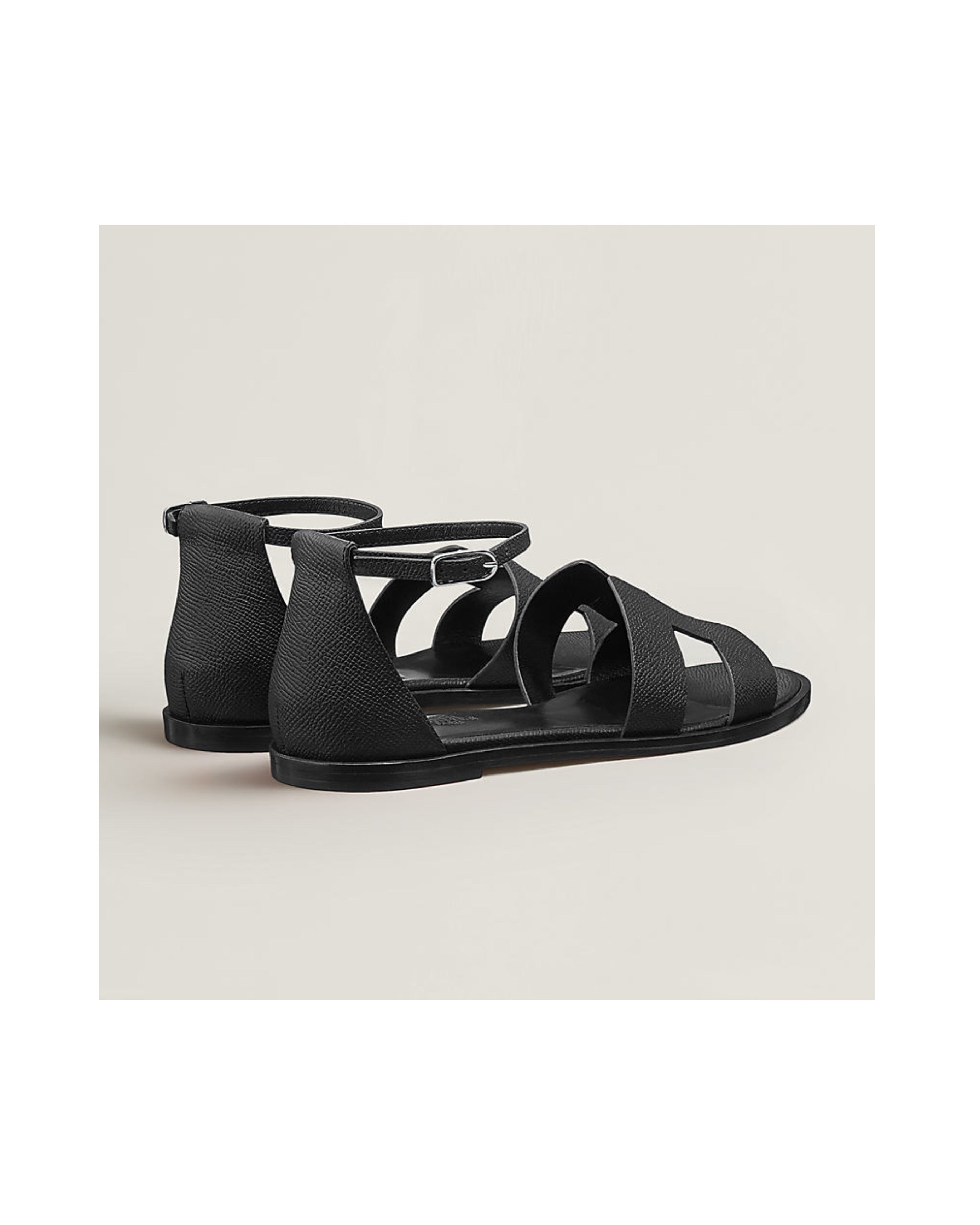 Black sandals on a light beige background