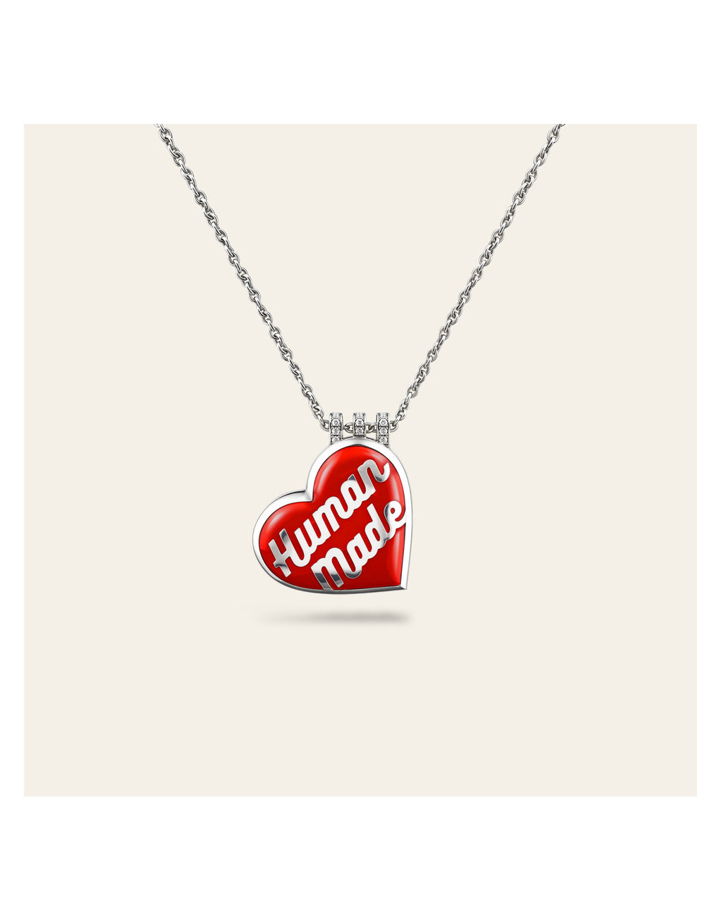 Heart-shaped pendant with 'Human Made' text on a chain against a white background