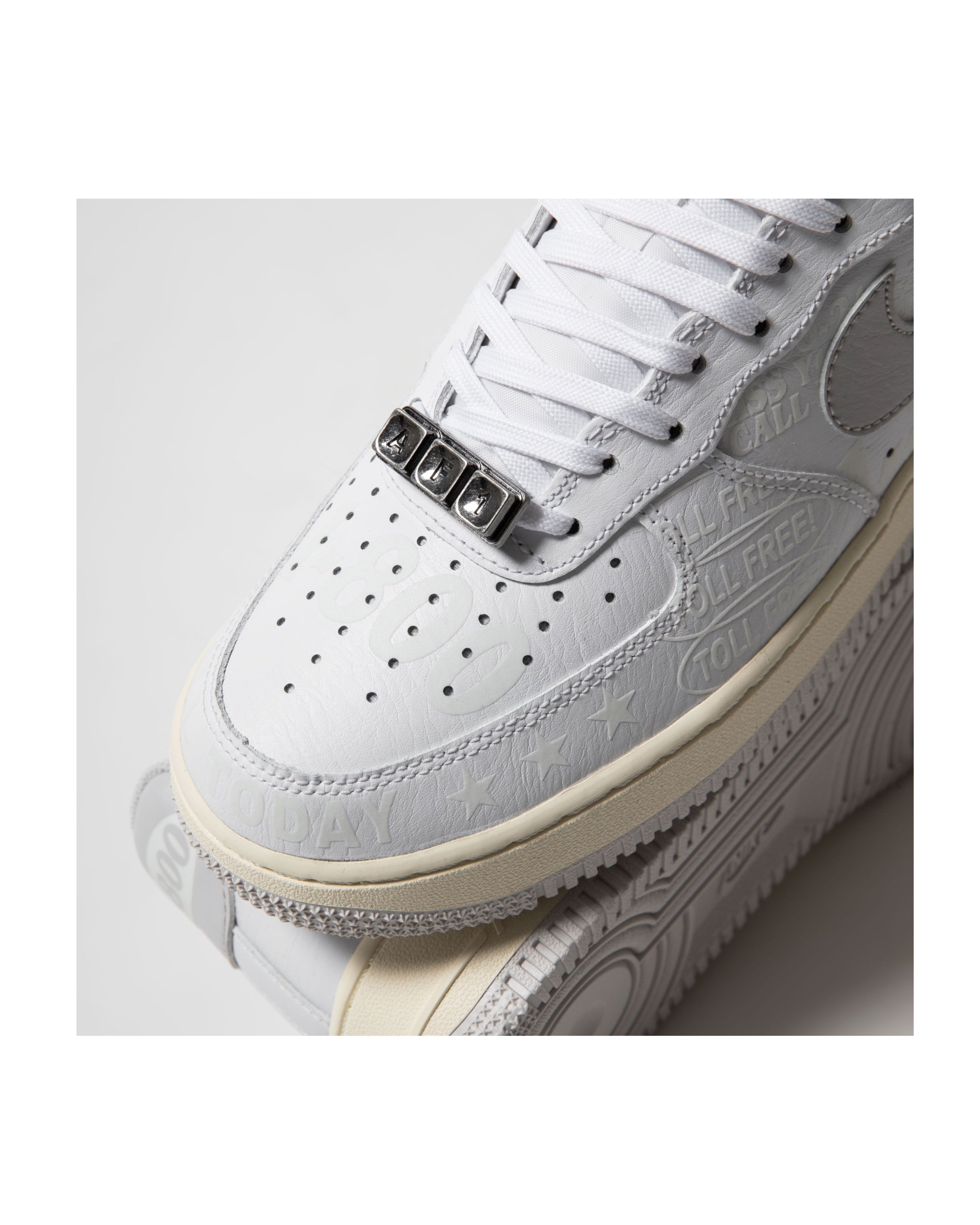 White sneaker with detailed design on a light gray background
