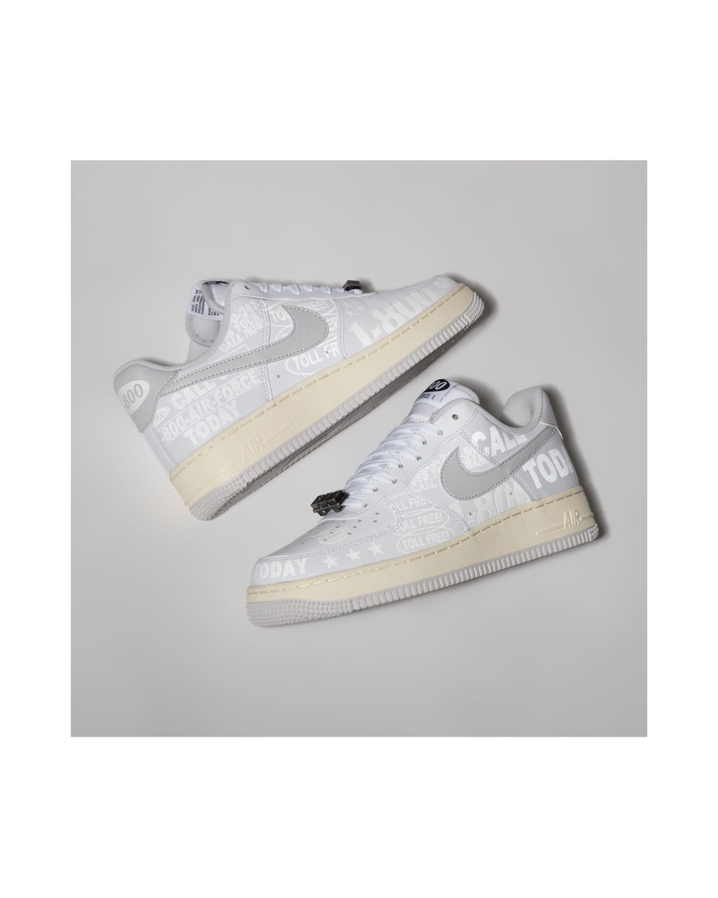 Pair of white sneakers with gray swoosh logo on a light gray background